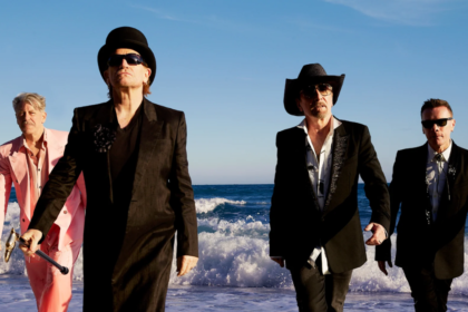 Integrantes de U2 caminando junto al mar durante una sesión fotográfica de la banda.