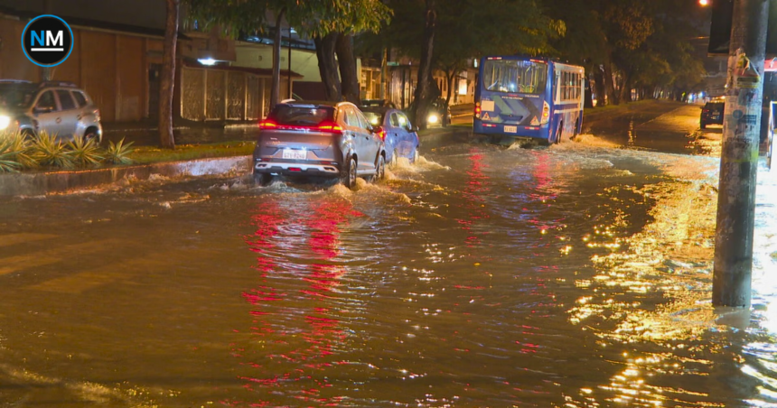 Vehículos circulan por una calle anegada de Guayaquil durante las fuertes lluvias registradas en la madrugada del 27 de septiembre.