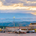 Vista del Aeropuerto Internacional Mariscal Sucre de Quito con torre de control, terminal y aeronaves en plataforma.