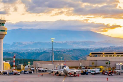 Vista del Aeropuerto Internacional Mariscal Sucre de Quito con torre de control, terminal y aeronaves en plataforma.