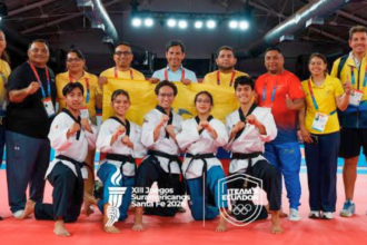 Equipo ecuatoriano de taekwondo posa junto a entrenadores y delegados tras ganar el oro en Freestyle Poomsae en Santa Fe 2026.