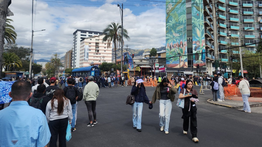 Estudiantes permanecen en los exteriores de la PUCE en Quito tras la evacuación por una amenaza de bomba.