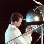 Técnico junto a una réplica del Sputnik 1, primer satélite artificial de la historia