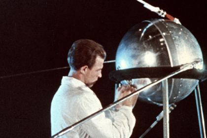 Técnico junto a una réplica del Sputnik 1, primer satélite artificial de la historia