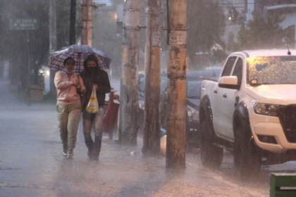 Personas caminan bajo una intensa lluvia en una calle de Quito