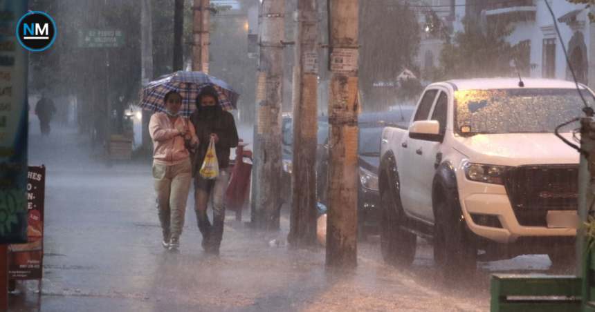 Personas caminan bajo una intensa lluvia en una calle de Quito