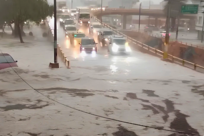 Fuerte lluvia provoca acumulación de agua en una vía de Quito, donde varios vehículos circulan entre sectores inundados.