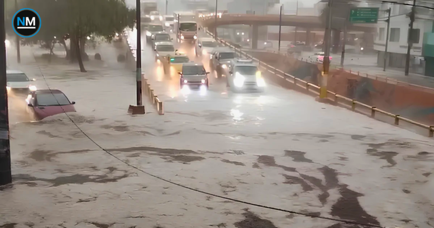 Fuerte lluvia provoca acumulación de agua en una vía de Quito, donde varios vehículos circulan entre sectores inundados.