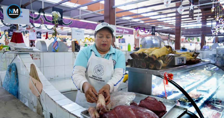 Puesto de venta de carne de res y cerdo en un mercado, con diferentes cortes exhibidos para los compradores.